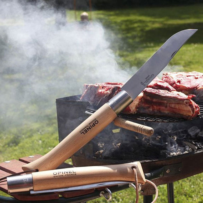 A giant Opinel knife leaning on outdoor grill.