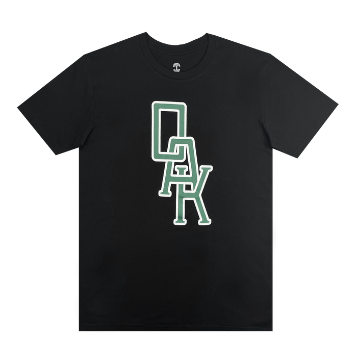 The OAK Monogram Tee by Oaklandish is a black, classic fit T-shirt made from 100% cotton. It features a stylized graphic with the vertically stacked word "OAK" in large, bold letters. The green lettering, outlined in white, has the "O" at the top, "A" in the middle, and "K" at the bottom with slight interlocking of the letters.