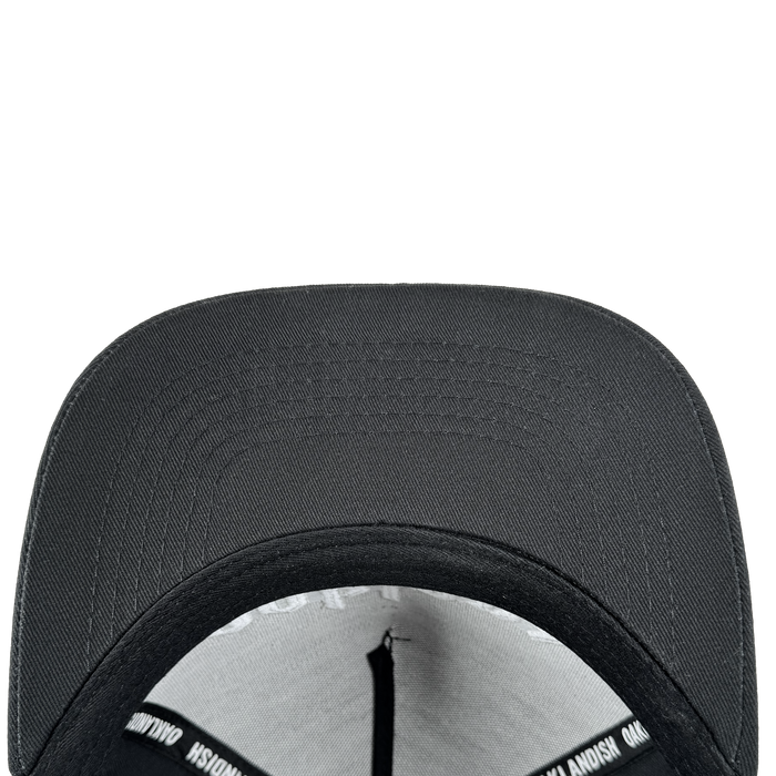 A close-up, top-down view of the Oaklandish Oakland 68s Panel Cap highlights its curved brim, textured fabric, interior sweatband, and a black lining with white text, all set against a plain light gray background.