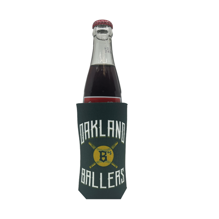 A bottle with a red cap is encased in the Oakland Ballers 16oz Can Cooler. The dark green koozie showcases the "OAKLAND BALLERS" text in white surrounding a yellow logo with two crossed baseball bats and the initials 'B' and '75', celebrating the Oakland Ballers, a professional baseball team in the Pioneer League. The bottle contains a dark liquid, possibly a beverage.