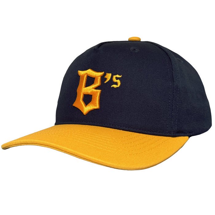 The Oakland Ballers 5 Panel Cap features a black snapback design with a curved yellow brim, bold yellow “B’s” logo, and matching top button—ideal for any Oakland baseball fan. Brand: Oakland Ballers. Plain white background.