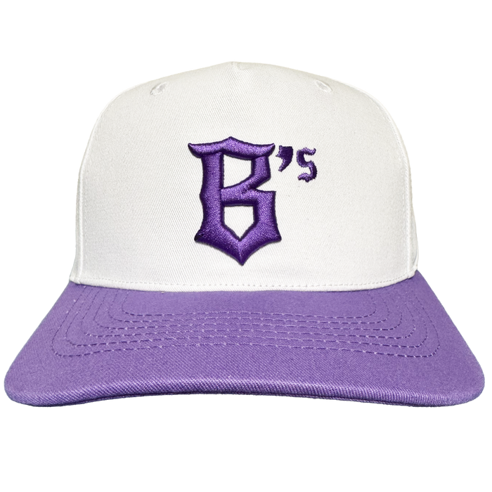 A front-facing view of the Oakland Ballers 5 Panel Cap by Oakland Ballers features a white crown with a light purple brim. The cap showcases an embroidered, stylized purple “B’s” logo on the front, honoring the dynamic Oakland Ballers baseball team. Set against a plain white background, detailed stitching is visible across the brim and crown.