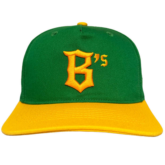 The Oakland Ballers 5 Panel Cap features a green structured crown, matching button, yellow brim, and a large yellow "B's" logo embroidered on the front. Brand: Oakland Ballers. Plain white background.