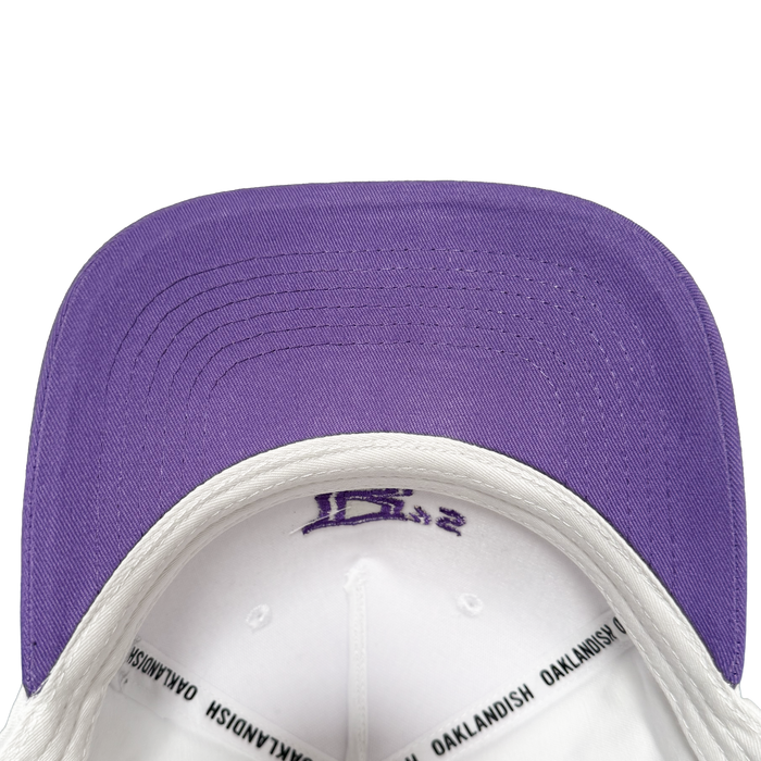 Showcasing the Oakland Ballers 5 Panel Cap, this stylish snapback features a crisp white crown with a solid purple brim—perfect for any Oakland Ballers supporter. The inside band is detailed with “OAKLANDISH” in bold black text, while purple stitching accents both the top and underside of the brim, capturing the vibrant spirit of the Oakland Ballers baseball team.