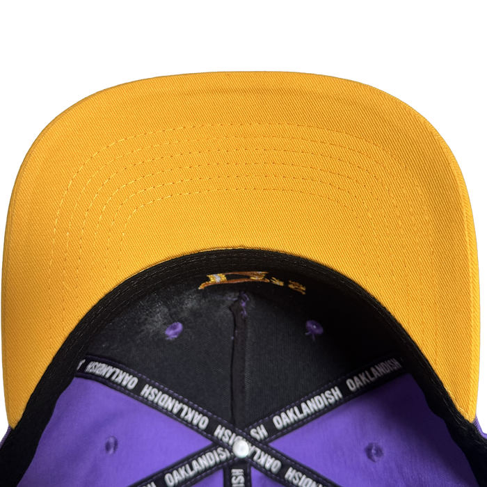 Overhead view of the Oakland Ballers 5 Panel Cap by Oakland Ballers, featuring a bright yellow bill, purple interior panels, black band, and “OAKLANDISH OAKLANDISH” text on the inner tape—a stylish nod to the proud spirit of Oakland baseball team fans.