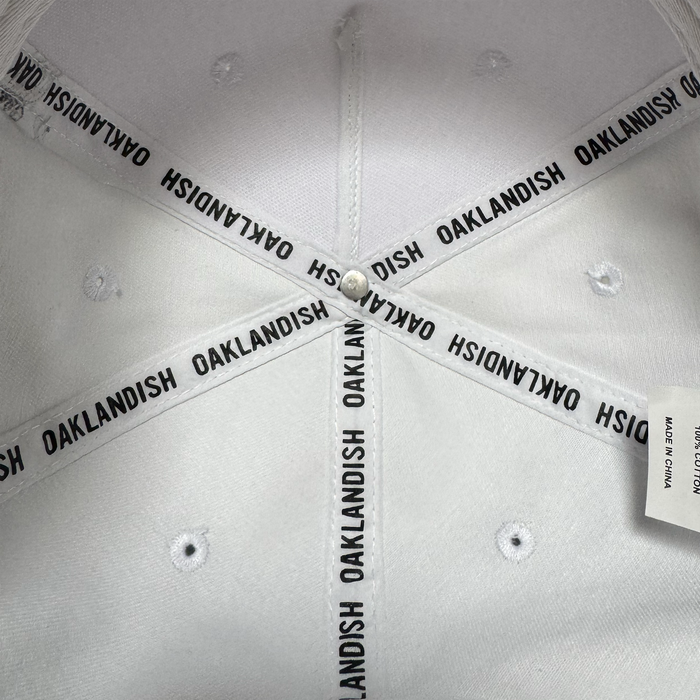 Close-up view of the inside crown of the Oakland Ballers 5 Panel Cap. Black “OAKLAND BALLERS” text repeats on interior fabric bands, evoking Oakland baseball spirit. Visible are white stitching and a “MADE IN CHINA” tag.