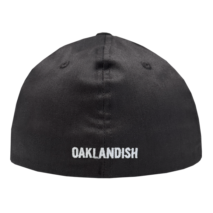 The Oakland Ballers Flexfit Cap by Oakland Ballers is a black fitted cap, shown from the back, with "OAKLANDISH" embroidered in white all-caps near the bottom edge and two stitched ventilation eyelets on each side of the top seam.