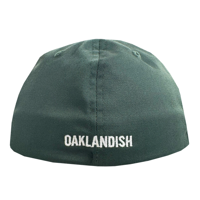 The Oakland Ballers Flexfit Cap, by Oakland Ballers, is a green cap with "OAKLANDISH" boldly embroidered in white on the back. Featuring two stitched eyelets and textured fabric, it celebrates local pro baseball pride.
