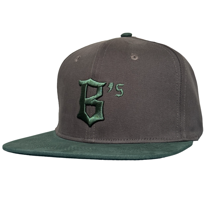 The Oakland Ballers Logo Hat, by Oakland Ballers, is a gray and green snapback with a flat green brim and features a large dark green Gothic "B's" logo embroidered on the front to honor the Pioneer League team. Background: plain white.