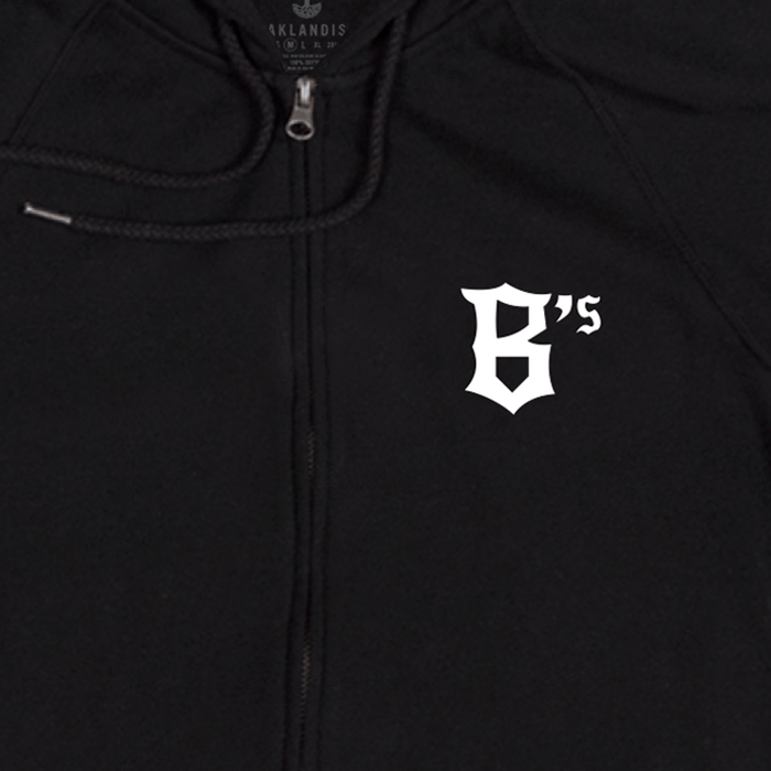 Introducing the Oakland Ballers Logo Zip by Oakland Ballers—a black zip-up hoodie featuring a white, Old English-style "B's" logo on the left chest, celebrating Oakland’s new Pioneer League baseball team. The design includes a visible drawstring near the zipper and a subtle "OAKLANDISH" tag at the collar.