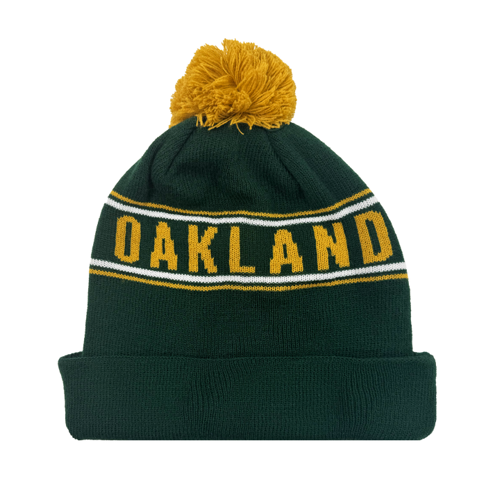 The Oakland Ballers Pom Beanie features a green knit with a yellow pom-pom, "OAKLAND" stitched on the front, white and yellow stripes, and a thick cuff for extra warmth—a stylish piece by the Oakland Ballers.