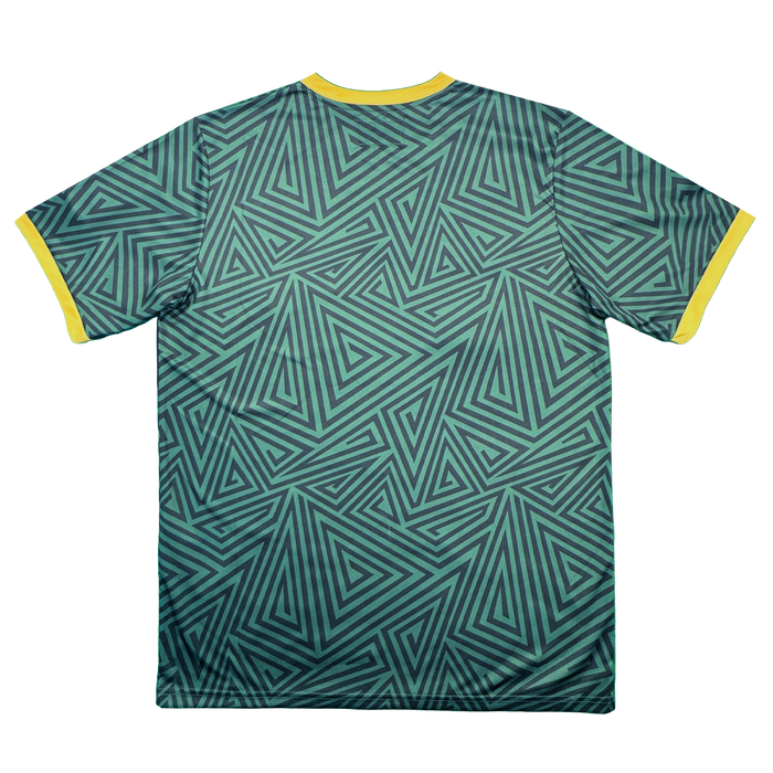 The Oakland Ballers SC Jersey by Oakland Ballers features a teal and black geometric triangular pattern, inspired by the vibrant style of the Oakland baseball team. Bright yellow collar and sleeve cuffs offer a striking contrast to the patterned fabric, evoking the look of a pro baseball jersey. The short-sleeve shirt is displayed laid flat with the back facing up against a white background.