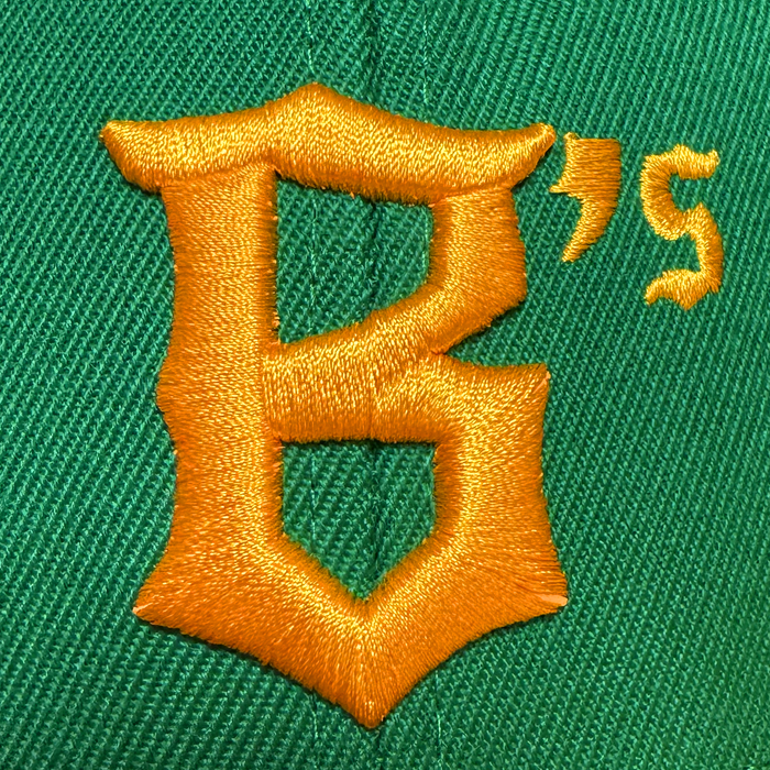 Close-up of the Oakland Ballers Snapback, a green hat featuring a bold, gold embroidered “B’s” above the seam—the thick, shiny stitching reflects the vibrant spirit of the Oakland Ballers brand.