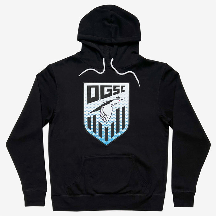 The Oakland Genesis Heron Hoodie by Partner is a black hooded sweatshirt with a front pocket, featuring a bold chest design that includes the letters "OGSC" above a stylized shield representing Oakland Genesis youth soccer. This eye-catching graphic also showcases a bird in white and blue tones against a dotted background, finished with white drawstrings at the neck.