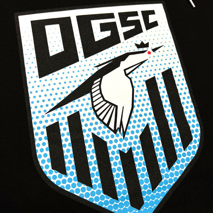 The Oakland Genesis Heron Hoodie by Partner showcases a stylized "OGSC" logo at the top. Beneath this text, a white crowned heron head with a red eye stands out in the center of a blue polka-dot patterned shield. The lower half of the shield features black vertical stripes of varying lengths on a black background, representing Oakland Genesis, a nonprofit organization dedicated to youth soccer.