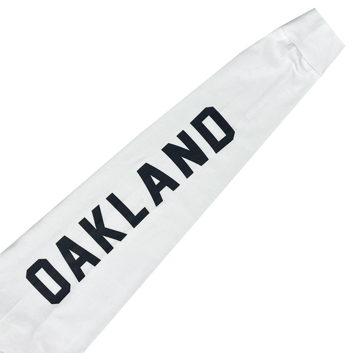 The Oakland Roots SC Classic 2.0 LS Tee is a white long sleeve t-shirt with "OAKLAND" printed in bold, black capital letters running diagonally across the design. Made from cotton, the sleeves end in cuffs. The simple and clean print contrasts strikingly against the plain white background, making it perfect for any Oakland Roots sports club fan.