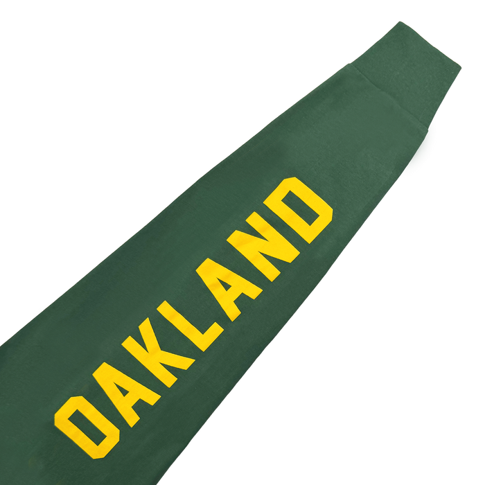 The Oakland Roots SC Classic 2.0 LS Tee by Oakland Roots SC is shown diagonally on a white background, featuring bold yellow "OAKLAND" lettering—evoking classic team style.