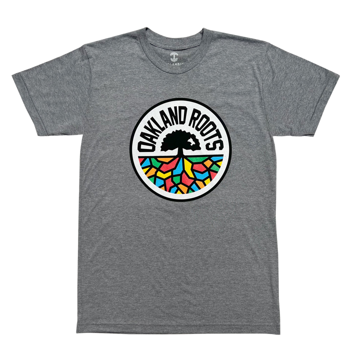 The Oakland Roots SC Classic Tee by Oakland Roots SC features a striking design with a large circular logo at the center. The logo showcases a black tree silhouetted against a vibrant multicolored mosaic background, encircled by the bold text "OAKLAND ROOTS" in black, representing this distinctive sports club. The gray t-shirt comes with short sleeves and a classic crew neckline.