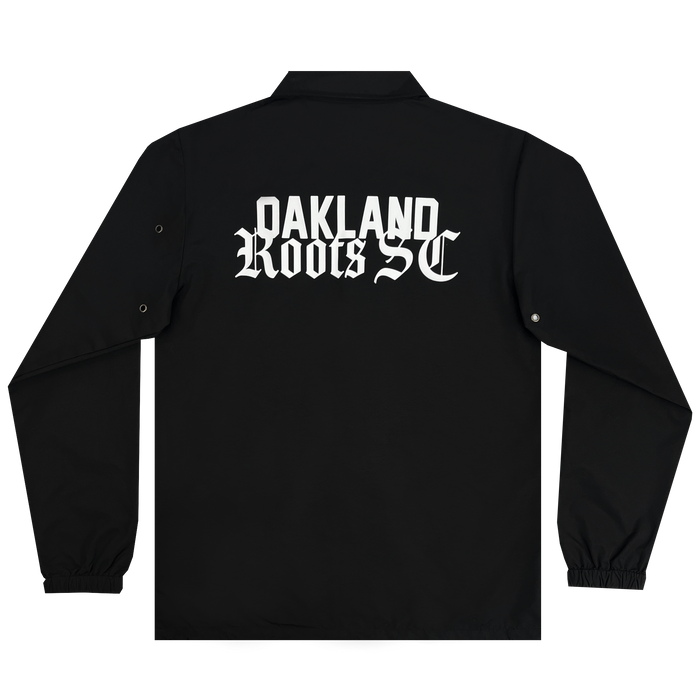 The Oakland Roots SC Coaches Jacket by Oakland Roots SC is a black, premium coach's jacket showcasing the words "OAKLAND ROOTS SC" in white, gothic-style lettering on the back. This water-resistant jacket features long sleeves with buttoned cuffs and a straight hem, making it perfect for fans of the Oakland Roots Sports Club.