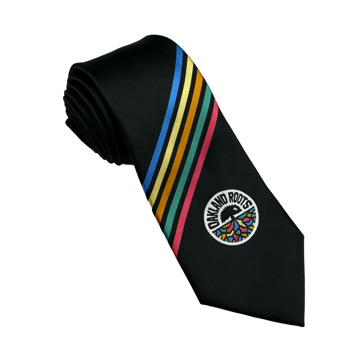 The Oakland Roots SC Tie by Oakland Roots SC is a black necktie adorned with diagonal stripes in blue, gold, green, red, and white. It features the iconic Oakland Roots emblem—a circular logo with stylized trees and "Oakland Roots"—highlighting its dedication to social good. A hint of Oaklandish flair near the bottom adds the finishing touch to the design.