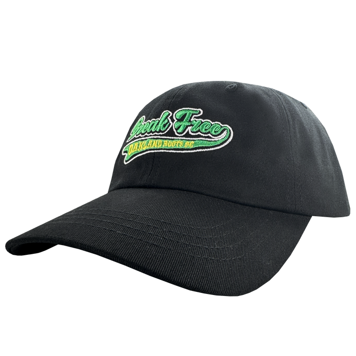 The Oakland Roots SC X Break Free Hat by Oakland Roots SC features "Speak Free" in green and white embroidery, yellow "Oakland Roots" text beneath, and a curved brim. Shown angled on a plain white background.