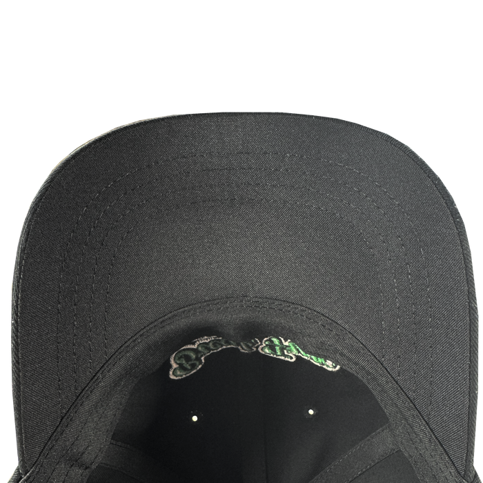 A close-up, top-down view of the underside of the black Oakland Roots SC X Break Free Hat by Oakland Roots SC, highlighting the curved brim’s stitching and a touch of green and white embroidery near the headband.