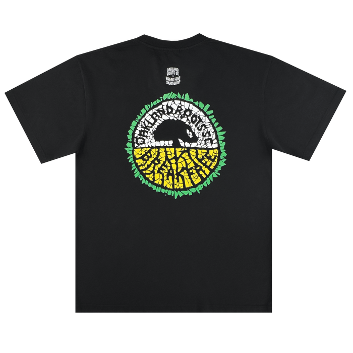 The Oakland Roots SC X Break Free Tee by Oakland Roots SC is a black classic fit t-shirt featuring a large circular back graphic with a black anteater silhouette, white and yellow mosaic pattern, green leaves, and "Good Faith Worldwide" above.
