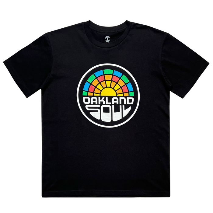 The Oakland Soul Logo Minus Tee is a black T-shirt with a circular logo: colorful geometric sunrise on top and "OAKLAND SOUL" in bold font below, honoring the city’s women’s soccer team. Brand: Oakland Soul.