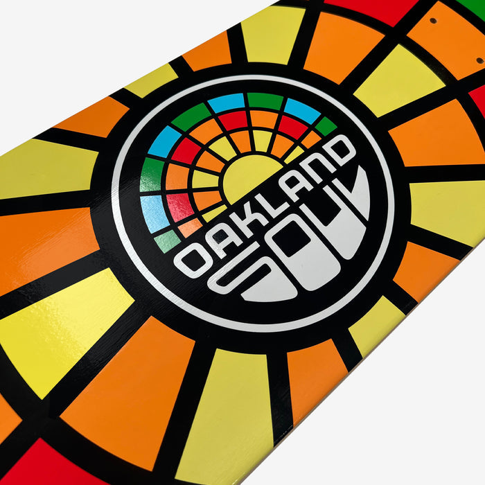 Close-up of the Oakland Soul Logo Skate Deck, made from 7-ply maple wood and showcasing a vibrant geometric design. The pattern features a colorful sunburst-like motif with yellow, orange, red, green, and blue segments radiating from the center. The text "Oakland Soul" is prominently placed in the middle of the design.
