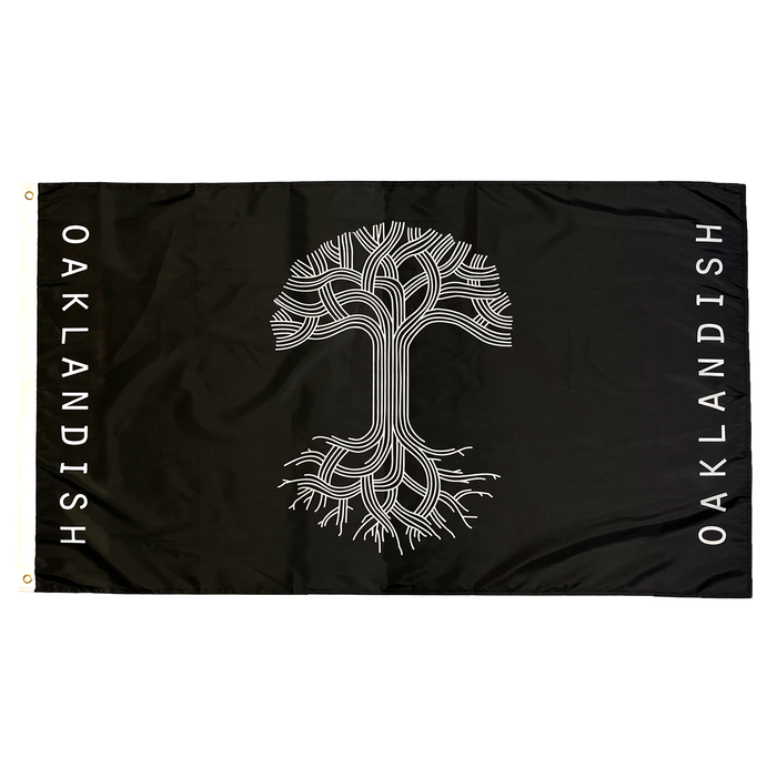 The Oaklandish Classic Logo Flag by Oaklandish features a rectangular black background with a striking white tree design at its center. The intricate branches extend to the flag's edges, and "OAKLANDISH" is boldly written vertically along both the left and right sides in white letters. Made from knit polyester, this flag includes two gold grommets on the left side for easy hanging.