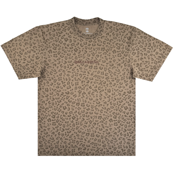 The Oaklandish Classic Logo Tee by Oaklandish is a men's oversized, heavyweight cotton short-sleeve crew-neck t-shirt in brown and tan leopard print with a subtle logo on the chest, set against a plain white background.