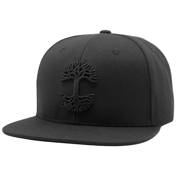 The Oaklandish Classic Snapback by Oaklandish is a black snapback hat featuring a flat brim and an embossed, monochromatic tree design on the front. This emblem, inspired by Oaklandish, showcases branches extending upwards and roots downwards, creating a circular motif. The headwear maintains a simple and sleek look without any additional logos or patterns.