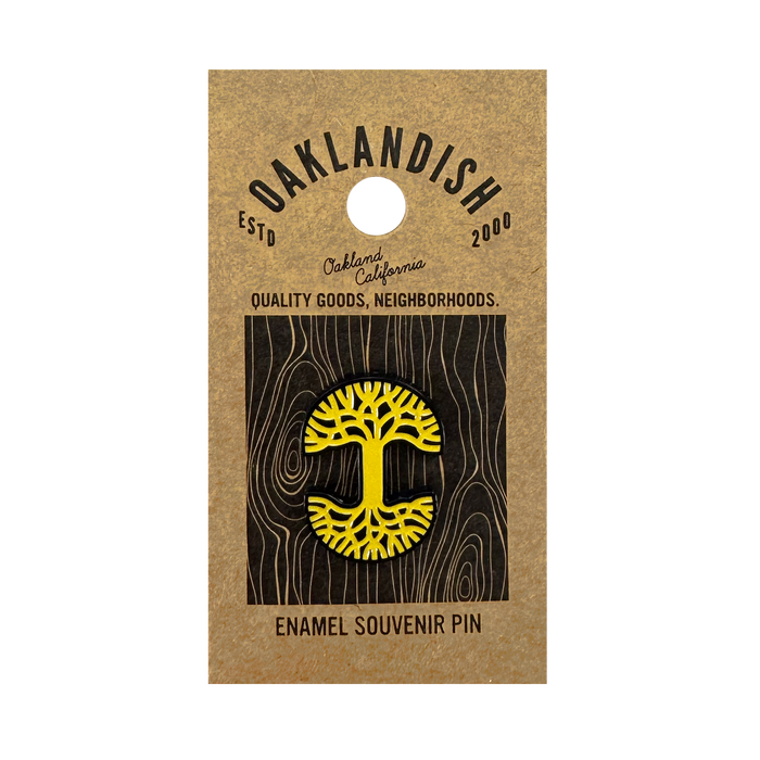 The Oaklandish Logo Enamel Pin is a yellow tree-shaped accessory with black details, attached to a brown card reading "Oaklandish ESTD 2000, Oakland California, Quality Goods, Neighborhoods. Enamel Souvenir Pin.
