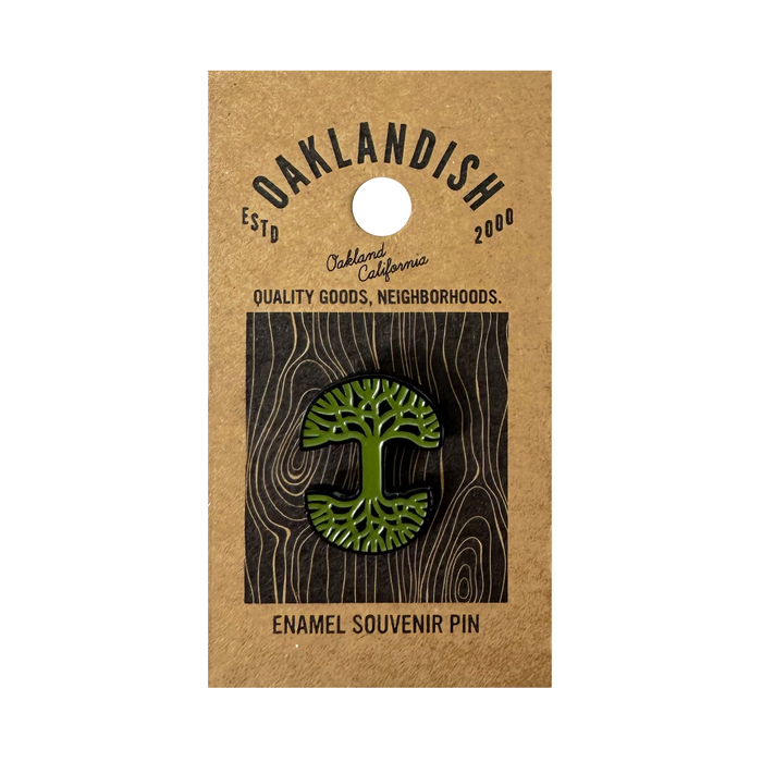 The Oaklandish Logo Enamel Pin, a green enamel accessory shaped like the iconic Oaklandish tree, is attached to brown backing reading "Oaklandish," "Oakland, California," "Quality goods, neighborhoods," and "Enamel Souvenir Pin.
