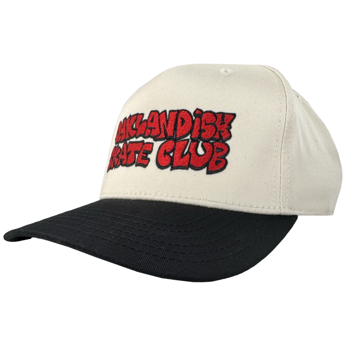The Oaklandish Skate Club 2-Tone Hat by Oaklandish features a cream crown, black bill, and bold red graffiti-style "OAKLANDISH SKATE CLUB" embroidery outlined in black—an ideal piece for skate culture. Shown on a plain white background.