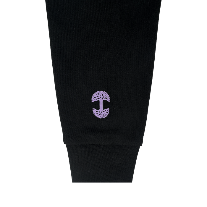 A close-up of the black GSV Odin Hoodie sleeve with a ribbed cuff in unisex sizing. Near the cuff, a purple Golden State Valkyries logo with mirrored branches and roots is embroidered. The background is plain white.