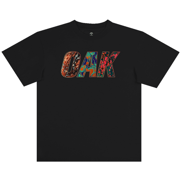 The Oaklandish Oil and Water Tee is a men’s black, heavy-weight cotton t-shirt featuring bold “OAK” lettering filled with vivid abstract patterns that stand out on the plain background.