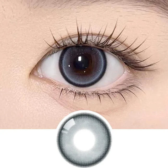 A close-up of a human eye with long lashes wearing Olola Meow Natural Siam Blue contacts by Olola, which enhance the iris. Below, a similar blue lens is shown separately on a white background.