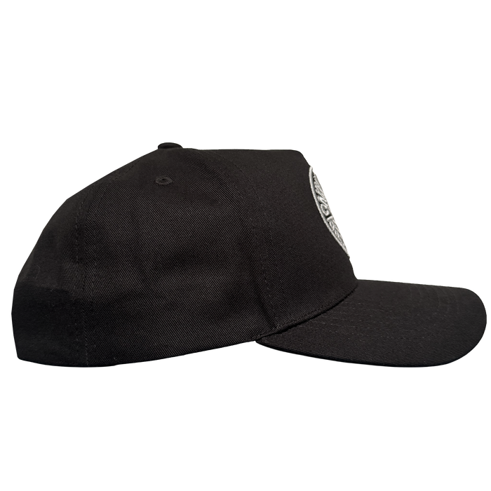 The ORSC 5 Panel Hat by Oakland Roots SC is a black baseball cap with a curved brim, structured crown, and top button. The front panel displays part of the white embroidered Oakland Roots SC logo on a plain white background.