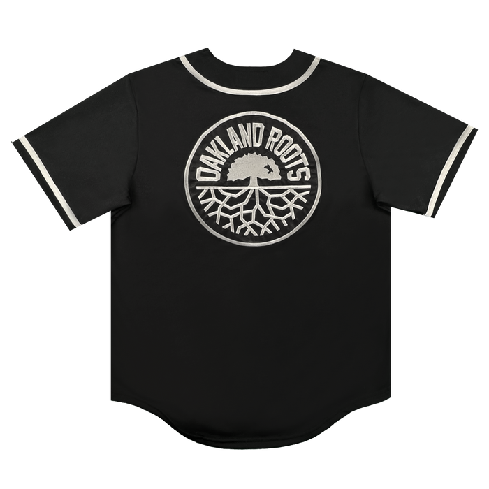 Introducing the ORSC Button Up Jersey by Oakland Roots SC—a black short-sleeve jersey accented with white trim on the collar and sleeves. This lifestyle piece proudly showcases a large, white circular Oakland Roots Sports Club logo on the back, featuring an oak tree above stylized roots and surrounded by the text "OAKLAND ROOTS".