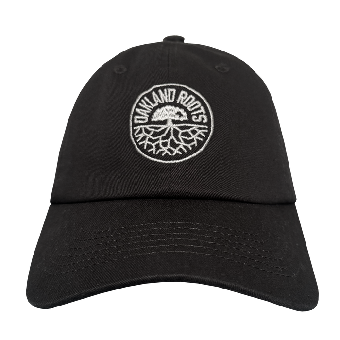The ORSC Dad Hat by Oakland Roots SC is a black cap with visible stitching and a curved brim, featuring the "Oakland Roots" logo—white "OAKLAND ROOTS" text above a tree root graphic within a circular border—embroidered on the front.