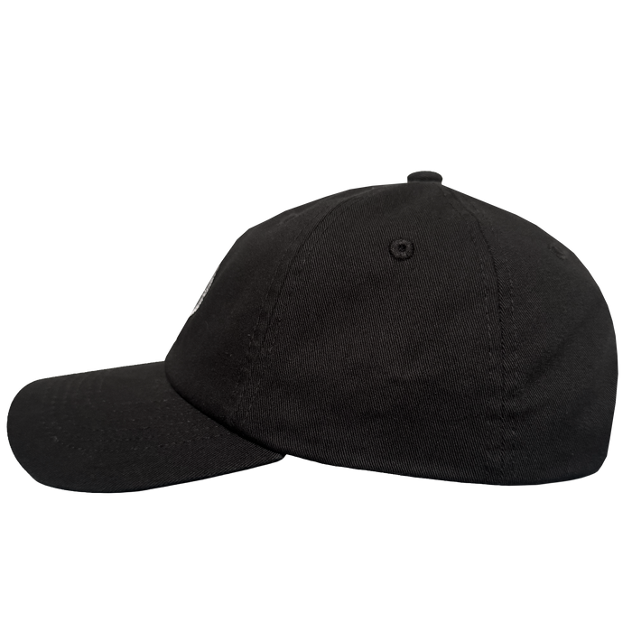 The ORSC Dad Hat by Oakland Roots SC is pictured in a side view against a light gray background. This plain black cap features a curved brim, visible stitching, and a top button, with no logos or designs shown.