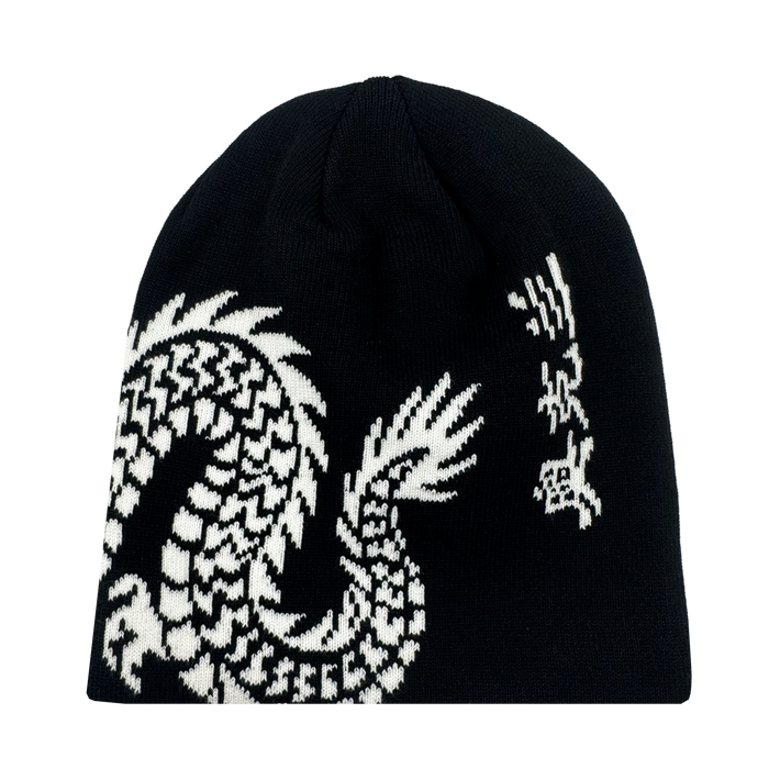 The ORSC Dragon Skully by Oakland Roots SC is a black knit beanie with a white, pixelated dragon graphic wrapping around one side, featuring its head and claw at the top right and its scaled body along the bottom.