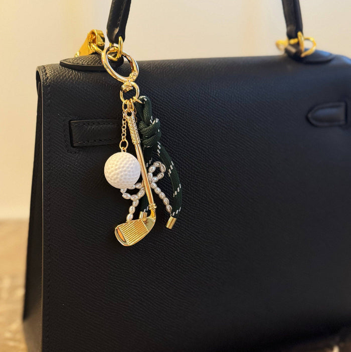 Ellison+Young Par Tee golf bag charm with gold and forest green accents, featuring golf club and ball charms.