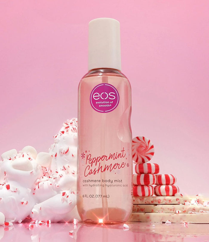 EOS Peppermint Cashmere body mist bottle on a pink background with candy-themed decor.