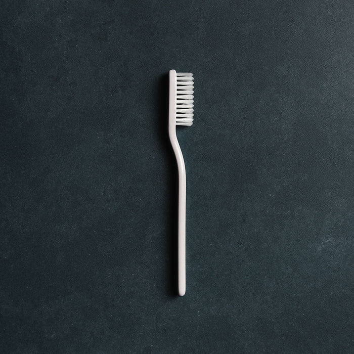 White toothbrush on a dark gray background