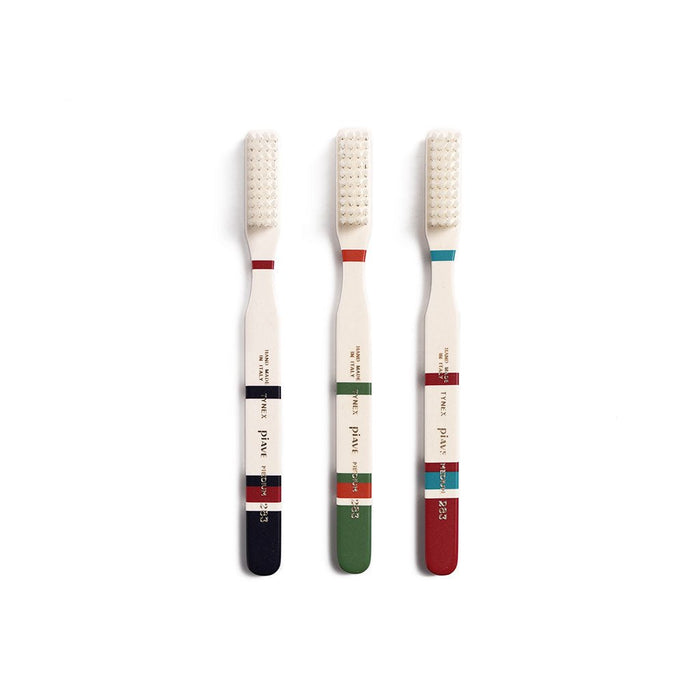 Set of three Roma toothbrushes in different colors on white background