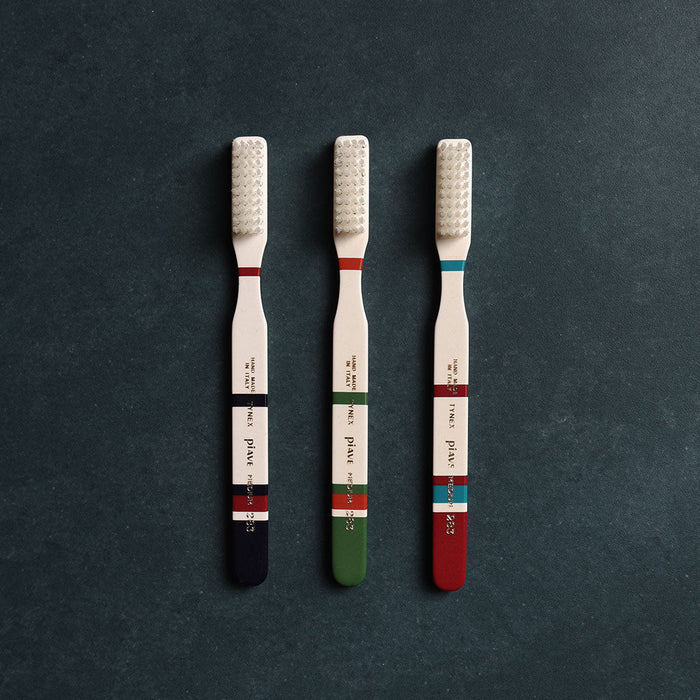 Set of three Roma toothbrushes in different colors on dark background