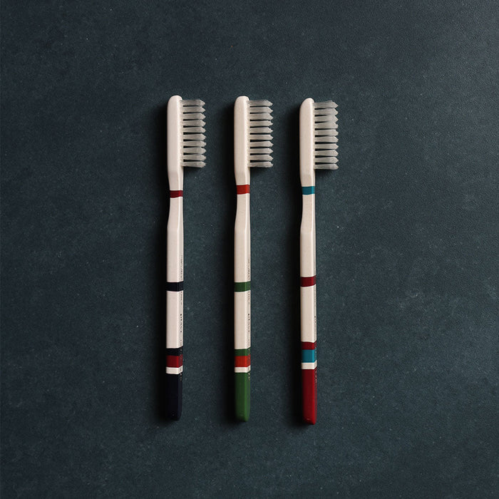 Set of three Roma toothbrushes in different colors on dark background