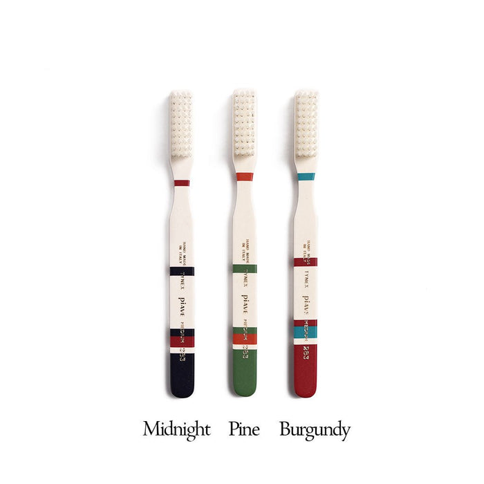 Set of three Roma toothbrushes in different colors on white background with labels